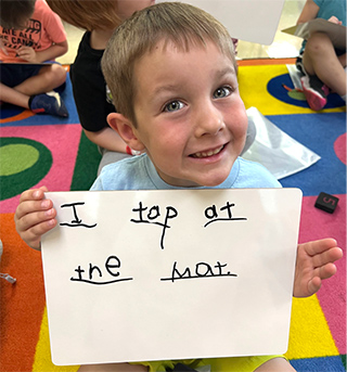Kindergarten boy holding sign